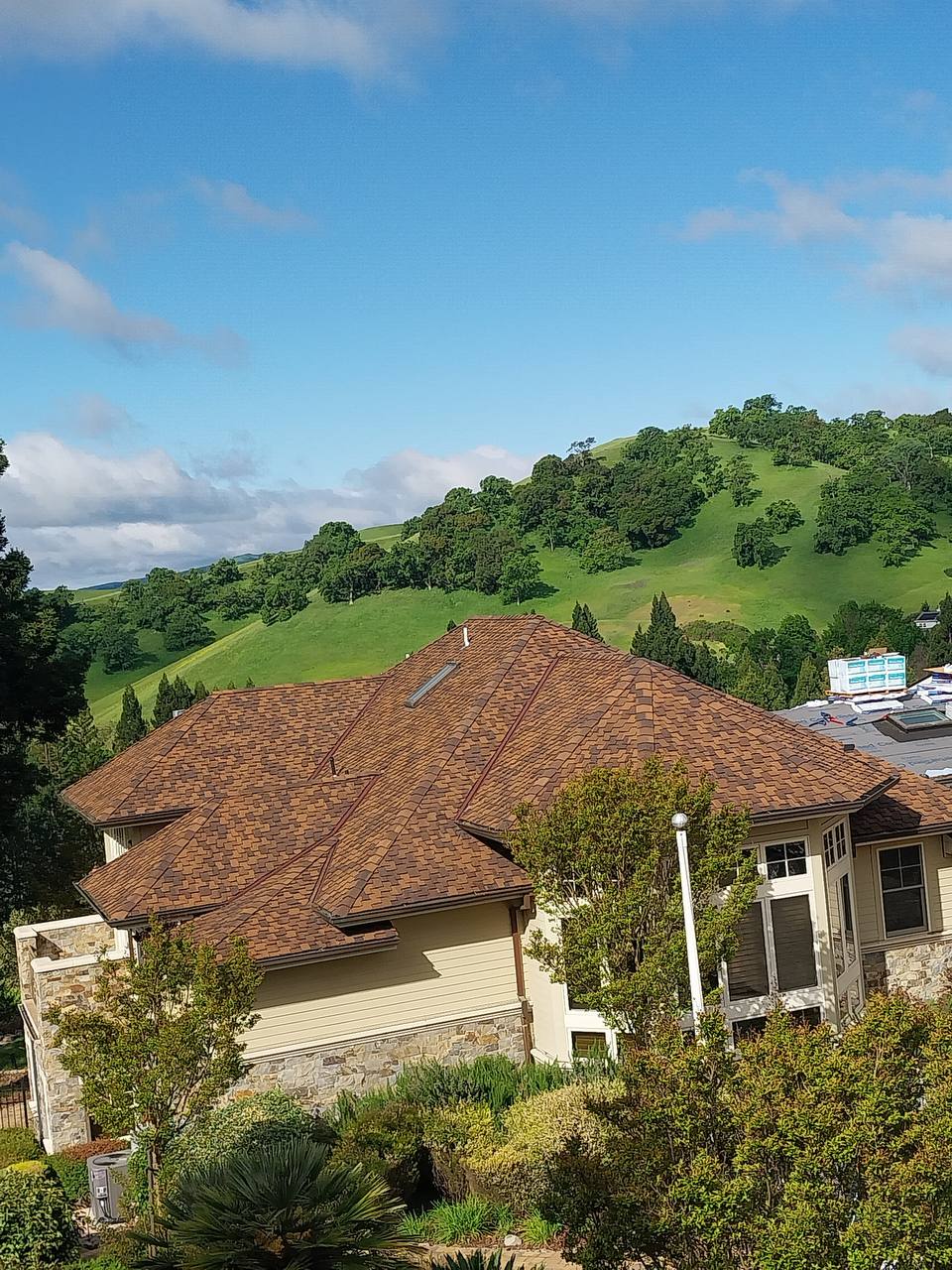 Finished CertainTeed Presidential Shake TL roof in Dark Brown, full house view with hillside backdrop